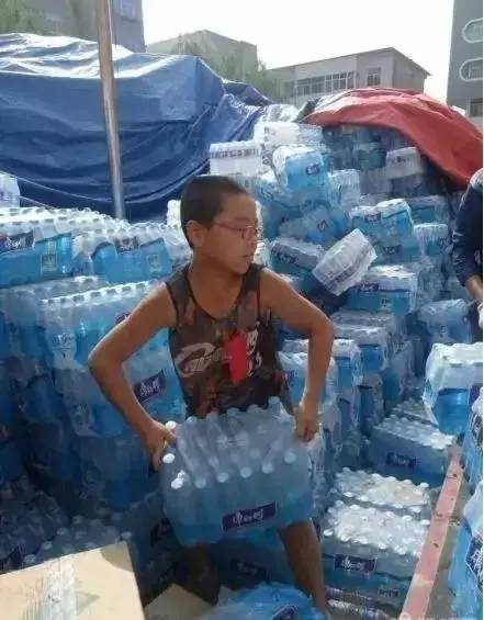 志愿者把礦泉水送到救援者手中志愿者攜手傳遞生命之源，礦泉水送到救援者手中